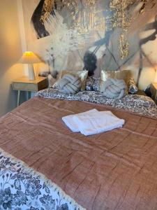 uma cama grande com duas almofadas em cima em Le studio des Halles - 8min CNPE - Chateaux & Vins em Bourgueil