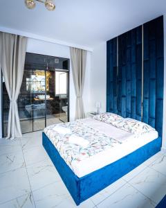 1 dormitorio con 1 cama grande y cabecero azul en Apartament BRYZA DE LUXE z JACUZZI en Gdynia