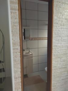 a bathroom with a sink and a toilet and a mirror at Kitnet da Fô in Pelotas +17 photos
