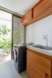 a kitchen with a washing machine and a sink at Namorada Atauá in São Miguel dos Milagres