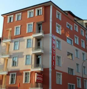 ein rotes Gebäude mit einem Hotelschild davor in der Unterkunft Hotel Kervansaray in Erzurum