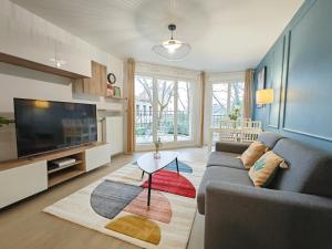 a living room with a couch and a tv at Maison de Charme - parking gratuit près de Paris & métro in Villejuif