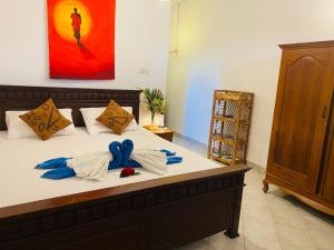 een slaapkamer met een bed met blauwe bogen erop bij Bay Street in Beruwala +27 foto's