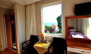 Zimmer mit einem Tisch und einem großen Fenster in der Unterkunft Önder Yıldız Hotel in Kızılot