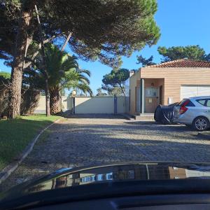 a car parked in a driveway next to a house at Little Paradise AL - Fão in Fão