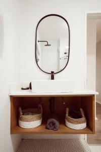 a bathroom with a sink and a mirror on a shelf at Luxury on Dorp in Stellenbosch