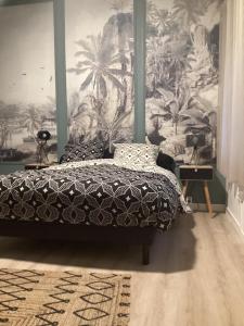 a bedroom with a bed and a mural of palm trees at Le Niaouli in Saint-Joseph