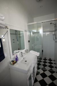 La salle de bains blanche est pourvue d'un lavabo et d'une douche. dans l'établissement Lavender House Bed & Breakfast, à Entrance
