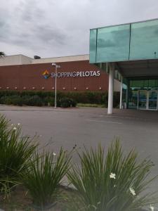 a building with a shopping plaza sign on it at Apartamento da Fô in Pelotas