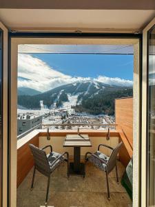 a balcony with a table and chairs and a view at Bjelasnica Apartment with the most beautiful view in Bjelašnica