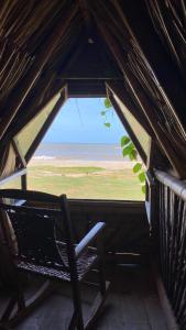 a window in a roof with a chair in it at Guajira Beach in Ríohacha