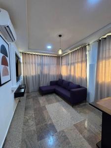 a living room with a blue couch in front of a window at Cactus Apartment in Galadima