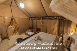 Un dormitorio con una cama en una tienda de campaña. en Sahara Luxury Traditional Camp, en Merzouga