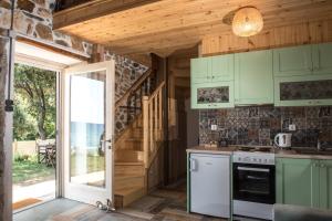 een keuken met groene kasten en een open deur bij La Baia Guest House in Karítsa