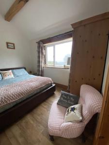 1 dormitorio con 1 cama, 1 silla y 1 ventana en Unique Stay on an Alpaca Therapy Farm with Miniature Donkeys North Wales, en Mold