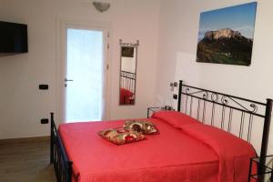 a bedroom with a red bed with a dog laying on it at Pietra di Bismantova Short Lets in Castelnovo neʼ Monti