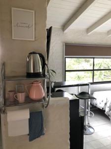 une cuisine avec une étagère avec des casseroles et des poêles dans l'établissement Pehuen Apartment, à Trelew