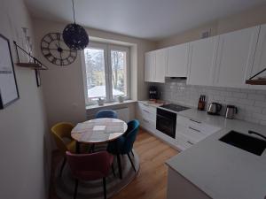 uma cozinha com mesa e cadeiras e uma cozinha com armários brancos em Apartament Solskiego em Mielec