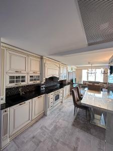 a large kitchen with white cabinets and a table at Luxury apartment in Skopje in Skopje