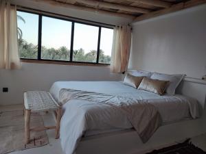 a white bedroom with a large bed and a window at Hôte sahara & spa TADIGHOUST in El Hara +68 photos