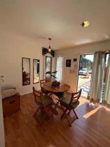 sala de estar con mesa de madera y sillas en Colmena House Villa Alemana en Villa Alemana