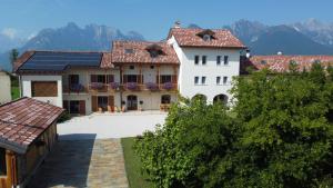 a large white house with solar panels on its roof at Corte Varola B&B Zia Marisa in Belluno