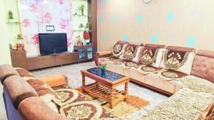 a living room with a couch and a tv at Sahara premium family homestay in Mysore