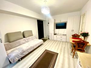 a bedroom with a bed and a table and a kitchen at Apartament Sara in Iaşi