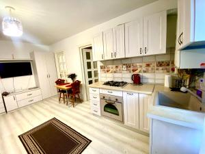 a kitchen with white cabinets and a table in it at Apartament Sara in Iaşi