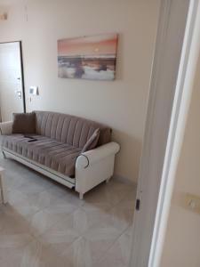 uma sala de estar com um sofá e uma pintura na parede em Alloggio Salice em Acerra