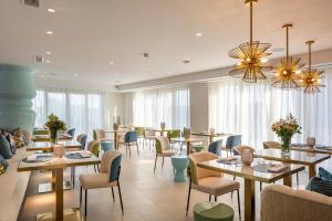a restaurant with tables and chairs and windows at Dionis Boutique Hotel & Spa in Jávea