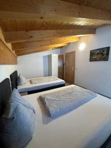 two beds in a room with wooden ceilings at LEO Apart 1 in Radfeld