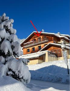 a snow covered house in front of a building at DUPLEX 50 m2 aux pieds des pistes les saisies hauteluce et contamines montjoie savoie 6 à 8 personnes 1 chambre et un coin nuit in Hauteluce