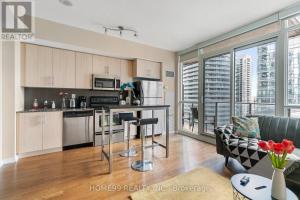 a kitchen and living room with a large window at Gorgeous Condo in Downtown Near CN Tower in Toronto