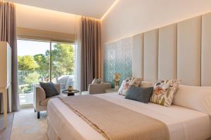 een slaapkamer met een groot bed en een groot raam bij Dionis Boutique Hotel & Spa in Jávea