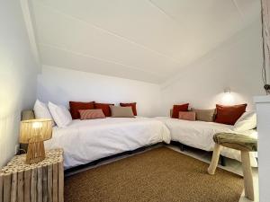 two beds in a room with a table and a lamp at La Bella Lola Estartit Rental in L'Estartit
