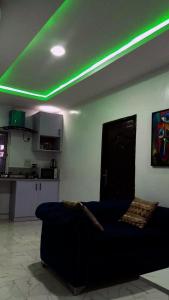 ein Wohnzimmer mit einem Sofa und grüner Beleuchtung in der Unterkunft JKA1-Bedroom Luxury Serviced Apartment in Lagos