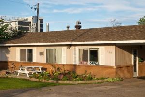 a house with a picnic table in front of it at Northlander Motel in Sault Ste. Marie