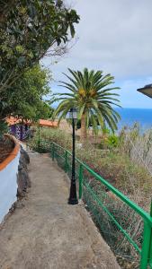 a street light on a sidewalk next to a green fence at Los Cerrajones: spectacular views from the cliff in Agulo