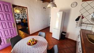 a kitchen with a table with a bowl of fruit on it at Los Cerrajones: spectacular views from the cliff in Agulo