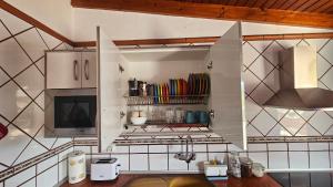 a kitchen with white cabinets and a stove top oven at Los Cerrajones: spectacular views from the cliff in Agulo