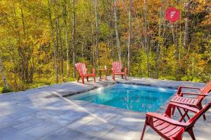 3 sedie e un tavolo accanto alla piscina di La North Star de Portneuf / Private SPA in forest a Pont-Rouge