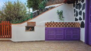a building with a fire place in the side of it at Los Cerrajones: spectacular views from the cliff in Agulo
