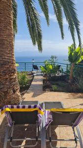 a couple of chairs sitting on a patio near the ocean at Los Cerrajones: spectacular views from the cliff in Agulo