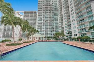 une grande piscine bordée de palmiers et de grands bâtiments dans l'établissement Luxury 2 Bedroom Loft Brickell-WaterViews, à Miami