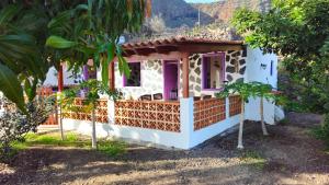 a small house with a pink and white facade at Los Cerrajones: spectacular views from the cliff in Agulo