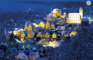 a city lit up in the snow at night at Frisch sanierte Ferienwohnung in Altensteig