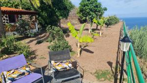 a pair of chairs sitting on a balcony overlooking the ocean at Los Cerrajones: spectacular views from the cliff in Agulo