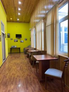 a room with tables and chairs and a yellow wall at HOSTEL124 in Baku