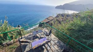 a view of the ocean with two chairs and a table at Los Cerrajones: spectacular views from the cliff in Agulo